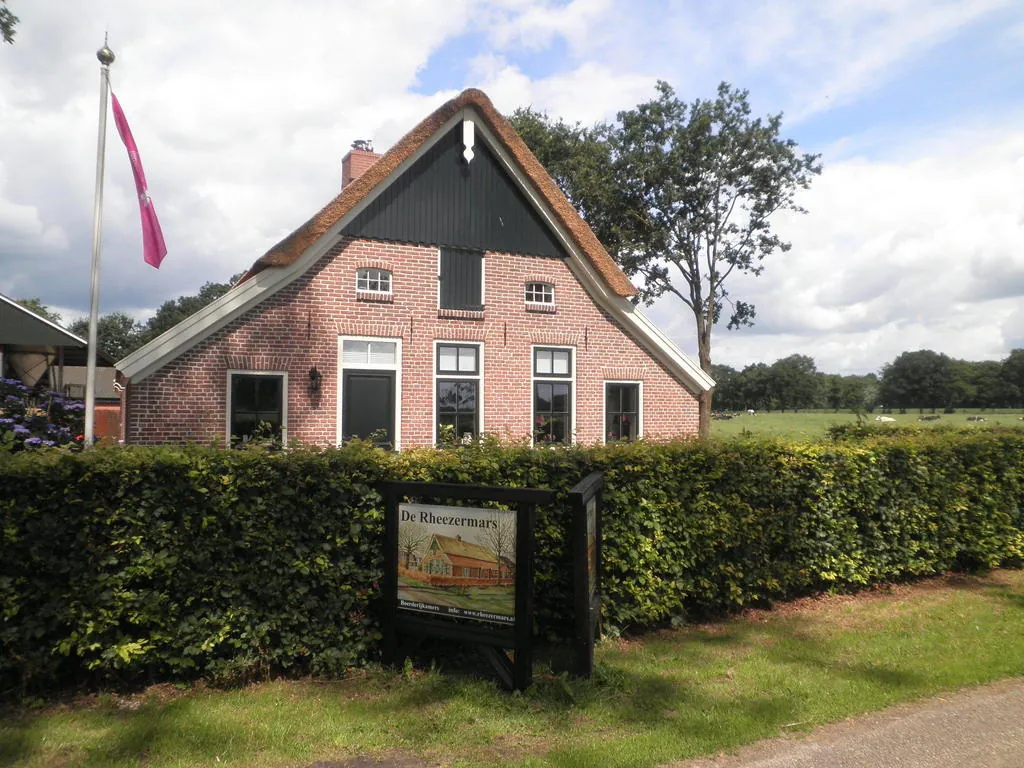 De verbouwde boerderij De Rheezermars in het groene landschap van Rheeze